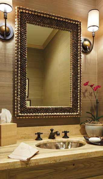 REPRINTED WITH PERMISSION VERO BEACH 8 In the powder room, tiger snail shells adorn the custom mirror and provide visual contrast to the travertine-topped vanity.