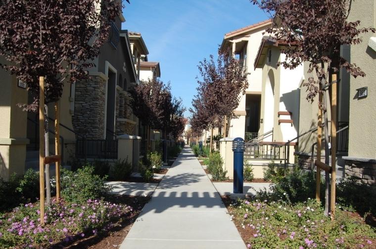 Townhomes typically share some common areas or common facilities within the townhome complex. Townhome unit entries can either be oriented to common open space areas or a residential street.