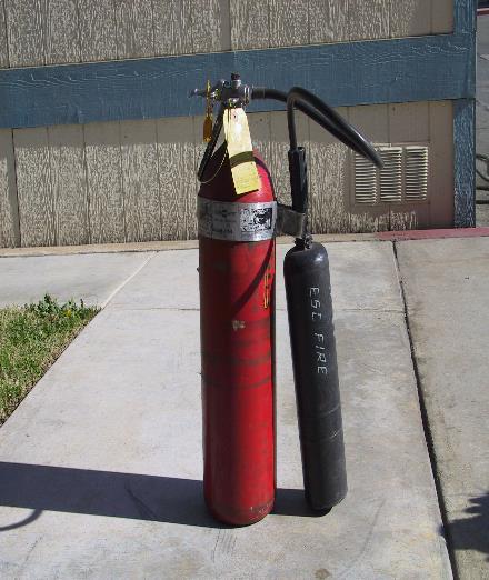 To do this, it is best to set the extinguisher on the ground and, while loosely holding the combination handle in one hand, pull out the ring pin with the other hand.
