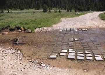 Figure A32. East Fork South Tongue River cable concrete block mat crossing. Note tilted blocks, exposed cables, and short mat length. Traffic is driving around the mat and the river has outflanked it.