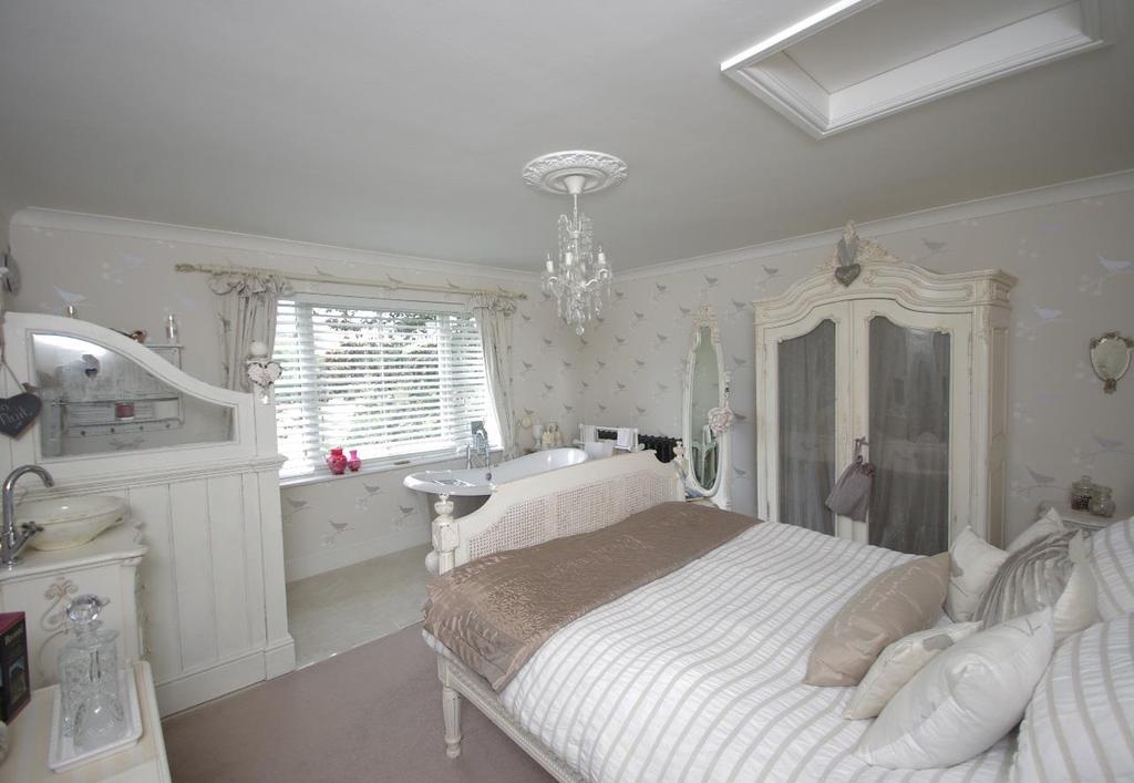 Bedroom 3 has an open plan en-suite which features a roll-top bath and enjoys views over the garden and moorland beyond.