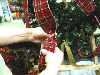 After curling the streamer, tuck it into the wreath. Don t pull it too tightly; you want to maintain the loose-flowing feel of the ribbon.
