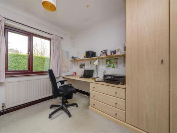 looking out across the rear garden There is a ceiling light point, ceiling coving, central heating radiator and to one wall there are a bank of fitted wardrobes with adjacent dressing table with