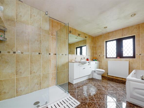 heating radiator, three wall light points, large chrome ladder style heated towel rail and fitted with a suite comprising panelled bath, vanity unit incorporating wash basin with mirror over and