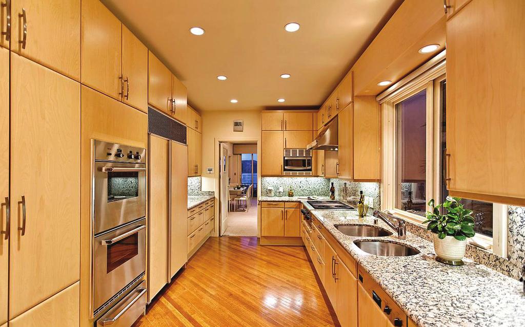 Adjacent to the formal dining room, the REMODELED KITCHEN boasts an abundance of granite countertops, granite backsplash, custom cabinetry, under cabinet lighting, stainless steel Thermador