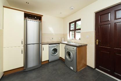 plumbing for washing machine and tumble dryer; space for fridge freezer; formica worktop; part tiled walls; tiled floor; recessed spotlights;