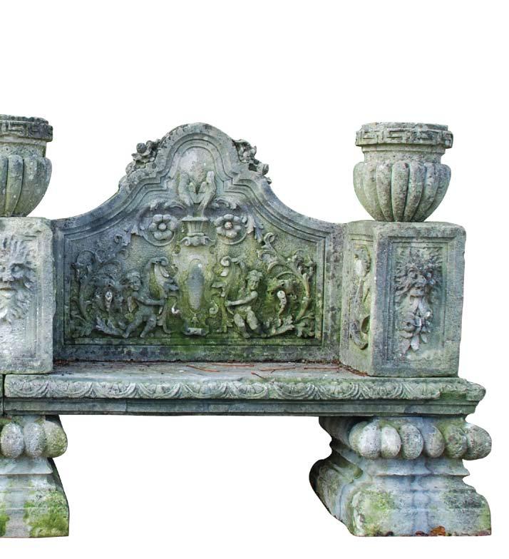 A 19th century Italian carved limestone garden seat, circa 1880 with double arched back flanked to either side by lobed urns on