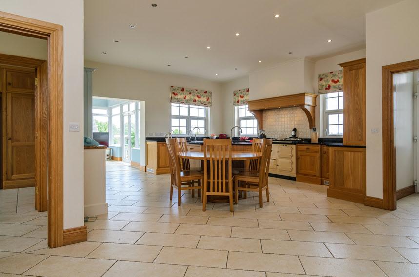 SUPERB LUXURY KITCHEN WITH DINING AREA: Handmade range of oak units with granite surfaces, double Belfast sink unit with mixer taps, recess for Aga with tiled splash back and extractor canopy,