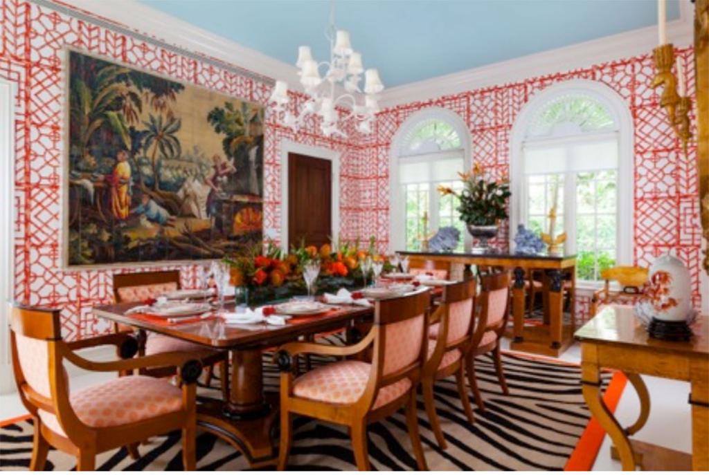 Red-patterned wallpaper in this dining room designed by Palm Beach, Florida-based designer Carleton Varney, president/ owner Dorothy Draper & Co. Inc.