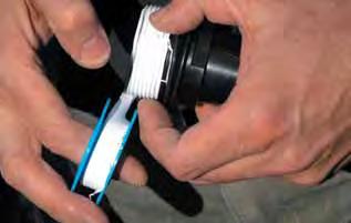 Apply teflon tape on the threaded area of the supplied drain plug and screw it into place.