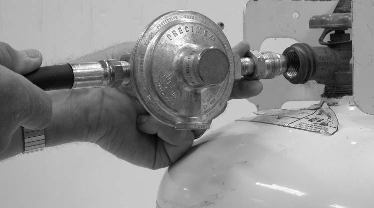 Thread the nut counterclockwise into the tank valve. Ensure regulator vent is pointed down. Tighten the nut securely with a wrench. See Fig. 5. FIG. 5 3.