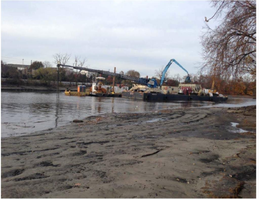 to convey material from barge) is depositing the active material/sand mixture over the post