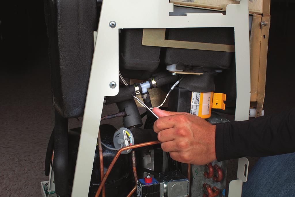 If device is equipped with an AC pump from the left side of the Control Module, disconnect the black compressor-evaporator tubing from the white plastic fitting it connects to.