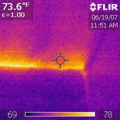 The infrared image clearly shows air infiltration from behind the rock.