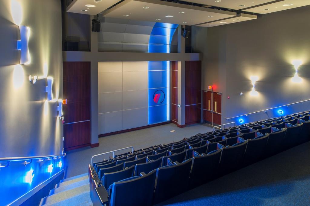 A180.10 Auditorium: An existing sales showroom was repurposed as an auditorium space, with simple suspended ceiling clouds for lighting and acoustic control.