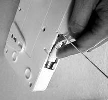 Screwing the unit to the wall INSTALLATION 1. Unscrew the two triangular hanging tabs located at the back of the Audio Alarm. 2.