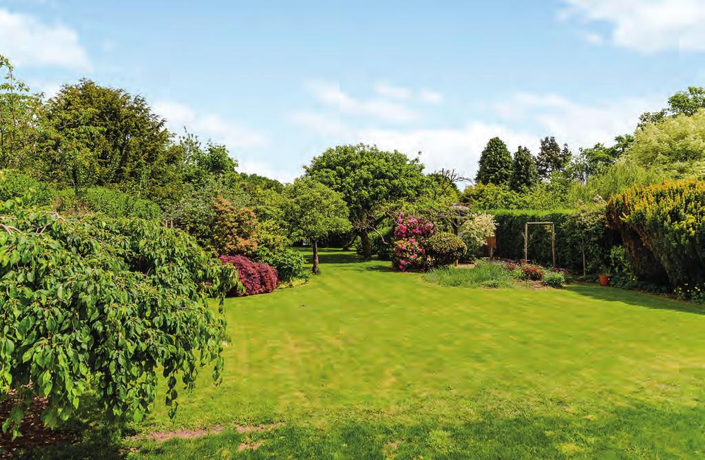 Wide steps lead down to the magnificent lawned garden with a very secluded outlook.