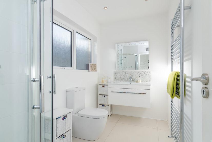 LUXURY SHOWER ROOM: Fully tiled shower cubicle with contemporary shower unit, low flush wc, contemporary vanity unit, heated chrome towel rail,