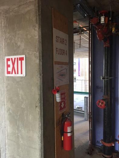 Fire extinguishers and air horns mounted at stairs.