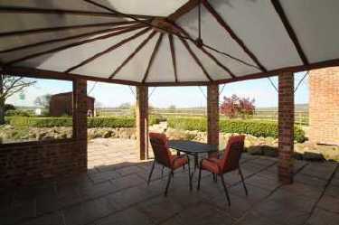 From the Kitchen a doorway leads to a delightful Outside Dining Area With vaulted roof.