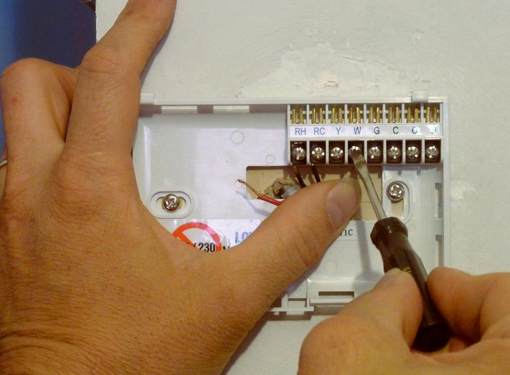 With needle-nose pliers straighten the two wires that were connected to the old thermostat and insert the red wire into the hole marked Rh and the white wire in to the hole marked W.