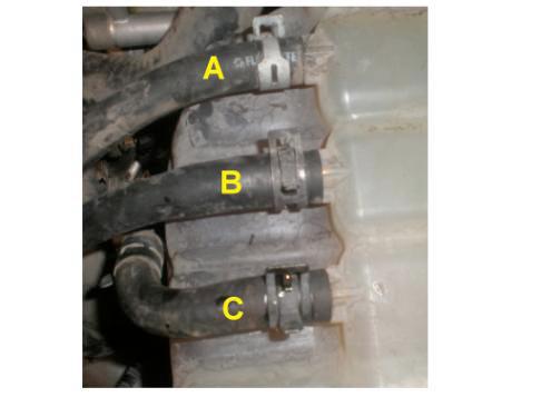 while at the same time using a rag or tennis ball to block the second thermostat hole. Keep blowing air until coolant stops running out the bottom radiator hose. f.