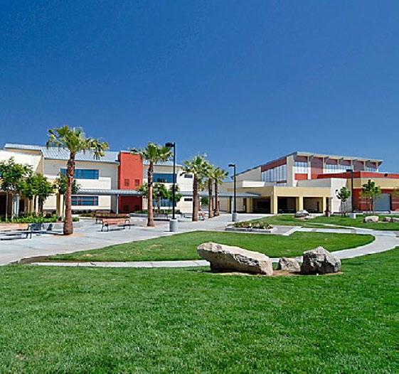 The schoolyard features an outdoor theater, a covered lunch area, and grassy knolls, as well as educational