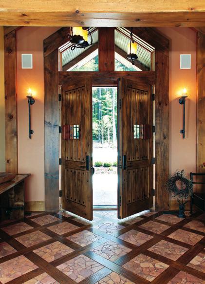 ABOVE: Andean Walnut double doors open to the entryway, which features broken limestone set in hardwood on the floors, vintage candle-style lighting and warm wood accents.