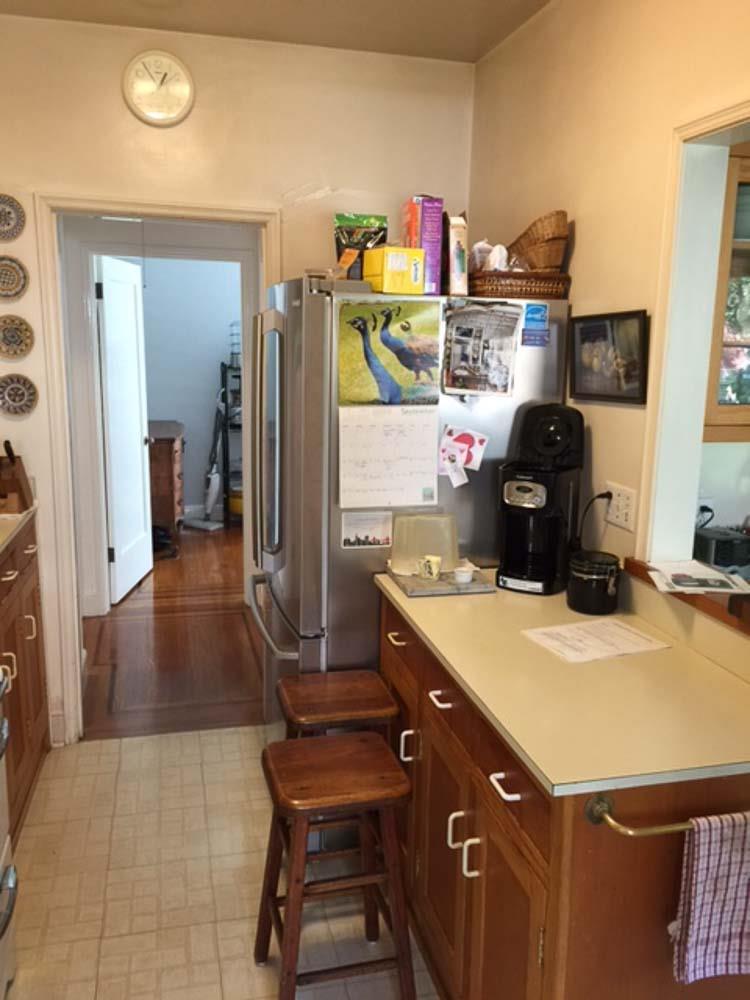 Before a small counter with seating in front extends into the center of the kitchen space.