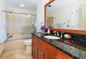 mirror and wall-mounted lights over vanity Bathtub/shower with