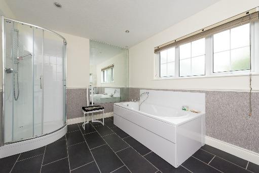 surround and fitted with chrome mixer tap; range of cupboards and drawers under; mirror and cupboards over; tiled splash back; close coupled wc; quadrant tiled shower cubicle with