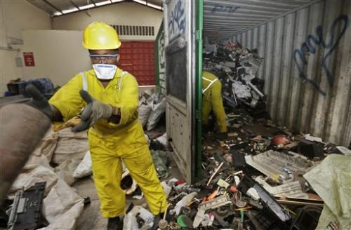 and sort through a container full of electronic waste that was collected from a Nairobi slum and brought in for recycling, at the East African Compliant