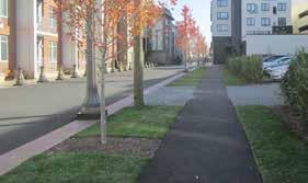 sidewalk and the road. The west side and rear of the parking garage is an undeveloped gravel strip and should remain a permeable surface.