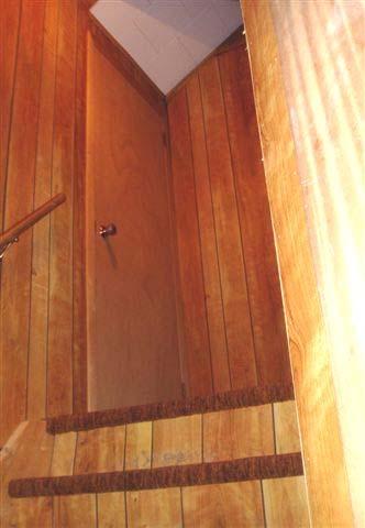 A storage closet off to the side of the stairway connects directly to an unsealed storage area and the
