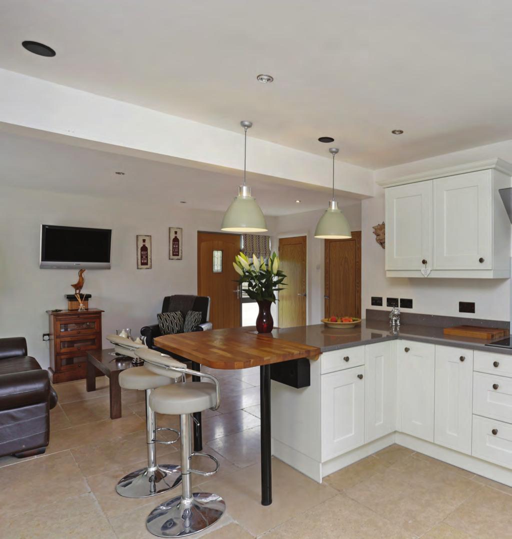 The kitchen and sitting room area is a gregarious space where the family cook, eat, relax and
