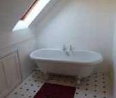 Velux roof light, white suite comprising roll top bath with claw and ball feet, low level w.c., pedestal wash hand basin, heated towel rail, two wall light points, under eaves storage, cushion flooring.