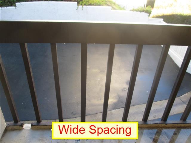 (1) Wide Spacing. The stringers at the exterior balcony railings are currently spaced greater than 4 inches.