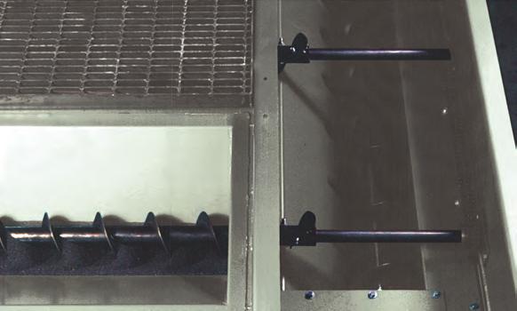 Below the grating are recessed hoppers, engineered to meter the abrasive onto the belt.