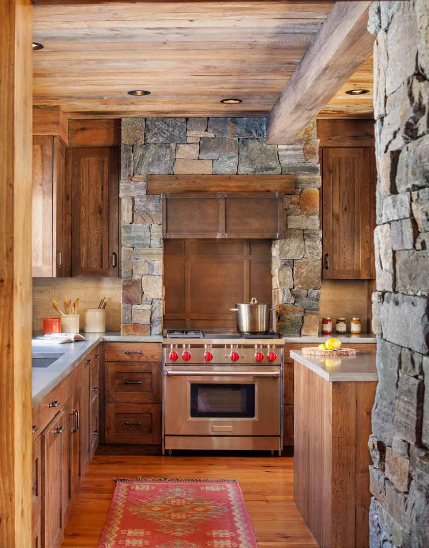 The same stone that is featured on the home s exterior and fireplaces is used in the kitchen, both around the stove and in the form of two columns that border a counter that separates the kitchen