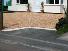 A strip of block paving or asphalt at the entrance can limit the loss and spread of gravel from the drive.