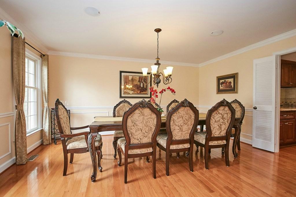 The delightful dining room is across the foyer from the living room and has crown & box molding, chair rail, hardwood floors and