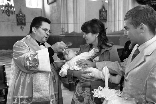 MOKSLO DARBAI Mažąją Vanesą krikštija Gervėčių parapijos klebonas Leonas Nestriukas. Krikštynų svečiai ruošiasi Bobučių skandinimui.
