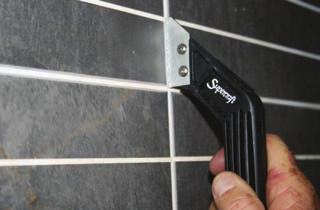 Sweep a rubber float or squeegee diagonally across the tiles to push grout into the gaps.