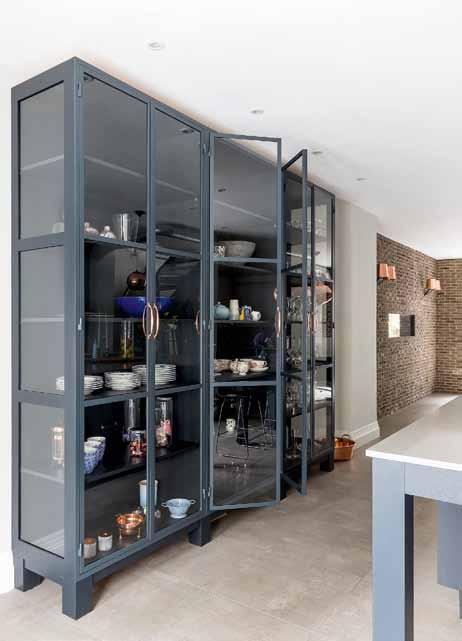 as seating and extra pull-out storage ON DIsPLAY Right The glass cabinet unit with Crittal doors is a bespoke piece designed for Anella to showcase a selection of the