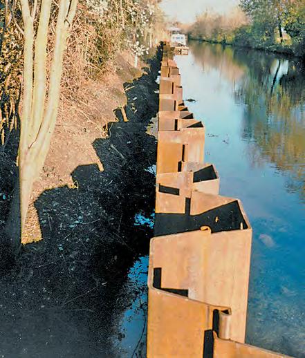 The piling was capped with an inverted steel channel section with mesh welded to the top to prevent movement of the above two courses of new bagwork, ending just below standard head water level (see