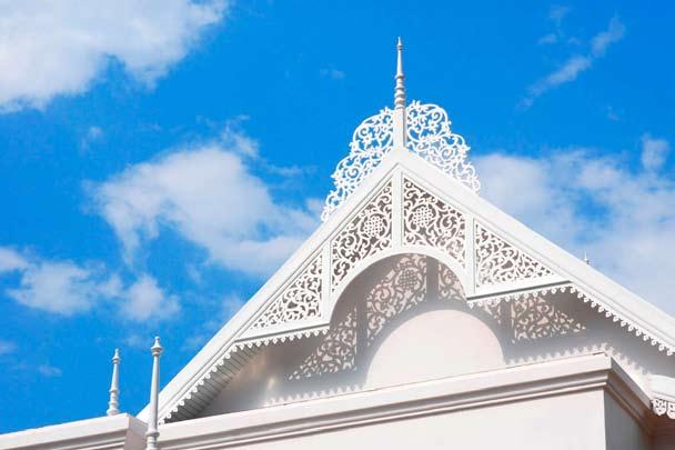 The gable of the hotel is decorated with exquisite white fretwork which provides a beautiful contrast to the blue