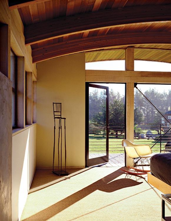 UNDER A BARREL ROOF Open beams and rough walls give the second-floor master suite a cool,