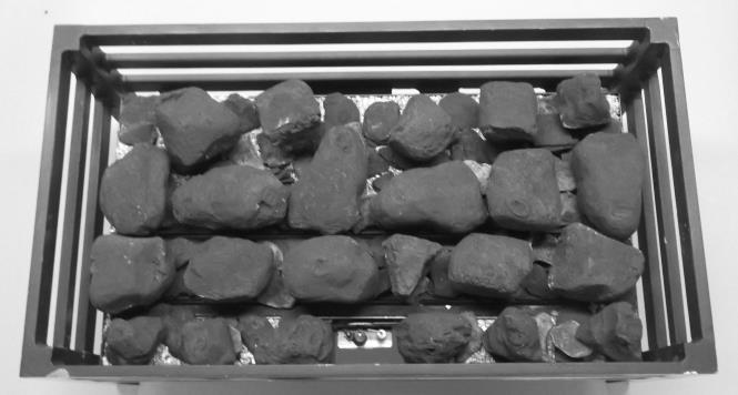 Place the remaining coals on top of the bottom coal layer in a similar way to the photograph above Position the straight left hand centre log resting on a bark piece at the front and on top of the