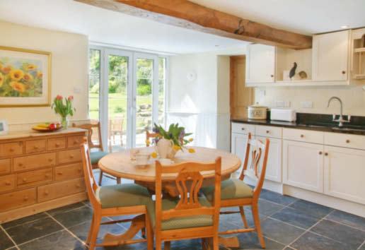 FARMHOUSE KITCHEN/BREAKFAST ROOM A well proportioned room which is light and airy with South facing French doors and side panels opening onto a slate terrace with the garden beyond.
