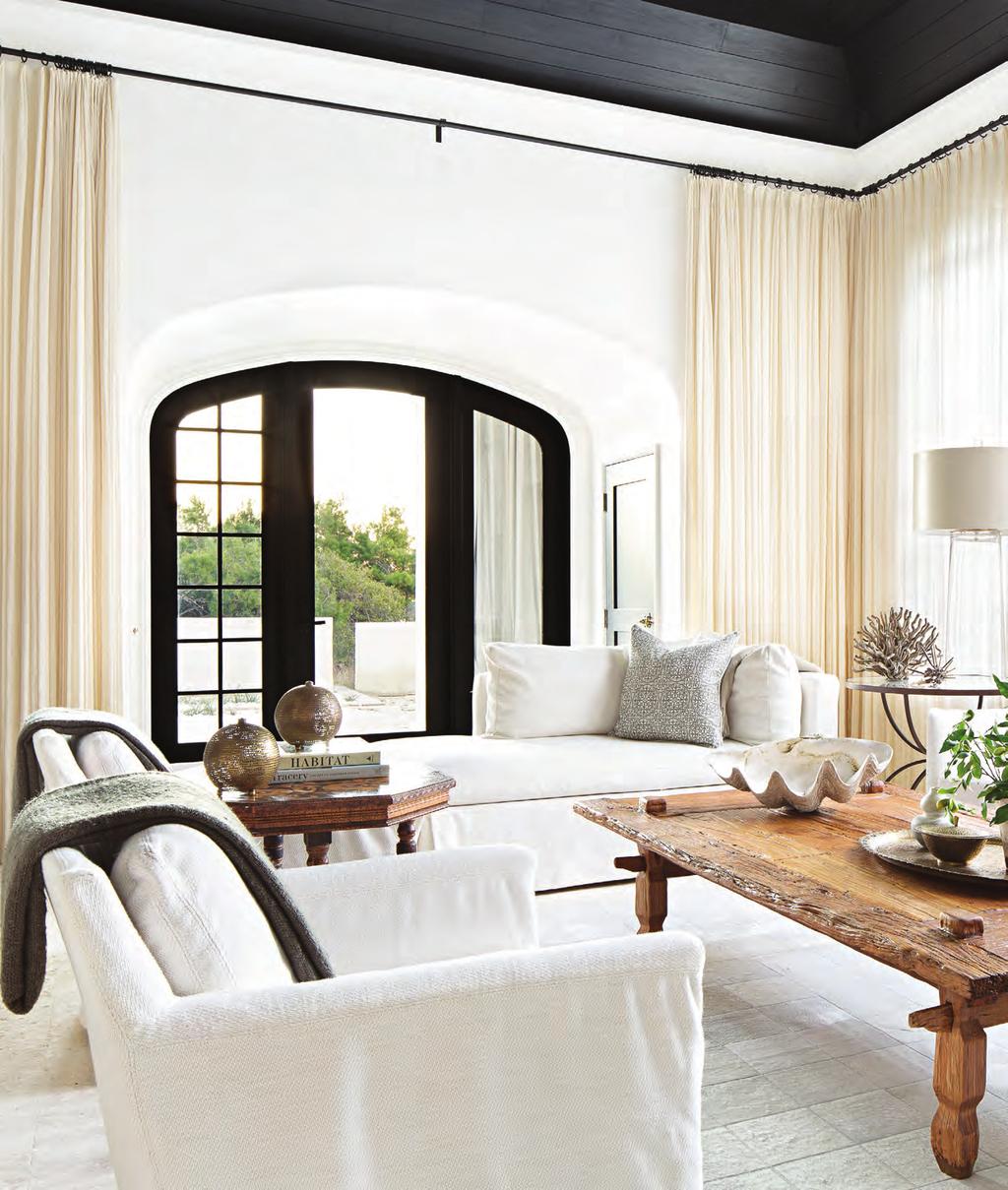 THIS PHOTO: Ebony-stained ceiling planks and window frames ground the living room s airy furnishings. Walls are coated with a thin veneer of luminous plaster.